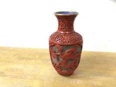 A Chinese cinebar vase depicting dragon, some losses and damage to base, measures 17cm high