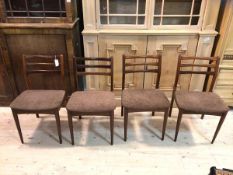 A set of four mid century Danish teak dining chairs with triple rail back over upholstered seat,