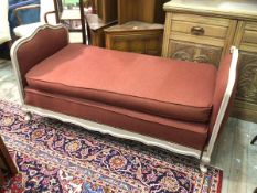 An early 20thc French daybed, the cream painted moulded frame upholstered in a herringbone wool