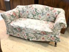 A 1930's / 40's two-seater sofa with serpentine back over scrolled arms on turned supports to front,
