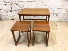 A teak triform Mackintosh table with fold over top with two nesting tables below terminating in