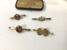 A collection of four bar brooches including one formed of two former sleeve links, both marked .375,