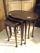 A c1930's figured walnut nest of three tables each with a tray top raised on slender cabriole