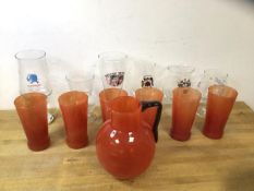 A set of six red grapefruit coloured tall glasses, each measures 14cm high, with matching pitcher,