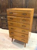 A mid century tallboy chest fitted with six drawers raised on shaped supports, measures 114cm x 65cm