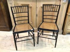 A pair of late 19thc aesthetic bedroom chairs of ebonised simulated bamboo form with cane seats