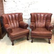 A pair of Tetrad Blake armchairs in studded brown leather with scrolled arms, seat cushions on