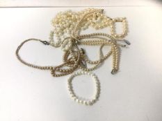 A collection of faux pearl necklaces and a fresh water pearl bracelet on elastic chain, measures
