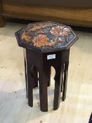 A small 20thc occasional table the octagonal top with relief carved floral design raised on a