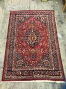 A North West Persian rug with medallion on scrolling vine and flower field and spandrels to