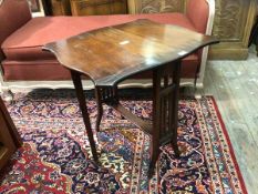 An Edwardian walnut Sutherland table the shaped top with two drop leaves raised on square tapered