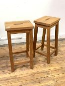 A Pair of light oak bar stools, the tops with pierced carry handles, raised on square splayed