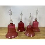 A group of four cranberry and clear glass bells, one with clapper, tallest measures 33cm high (4)