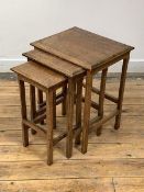 A 20th century oak nest of three tables, the rectangular canted tops raised on square section