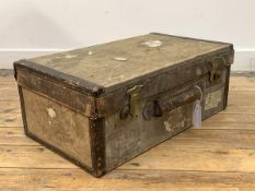 An early 20th century canvas covered travelling suitcase with remnants of old paper labels, H34cm,