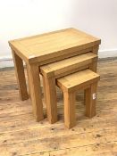 A Contemporary solid oak nest of three tables, the rectangular tops raised on square chamfered