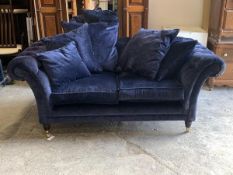 A Chesterfield style two seat sofa, upholstered in deep buttoned blue fabric, with squab and scatter