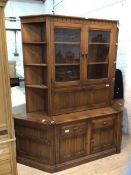 Ercol, an elm dresser with two glazed doors with plate rails to interior over full front door having