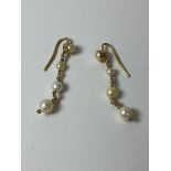 A pair of yellow metal graduated pearl drop diamond earrings