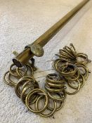 A Large early 20th century brass curtain rail, with brass wall brackets and various curtain rings,