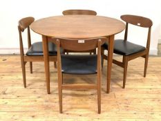 A Vintage mid century teak extending dining table, the circular top pulling to reveal a magic