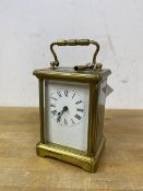 A four glass carriage clock, roman numerals to dial, measures 14cm high to top of handle