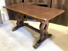 An Arts and Crafts style oak refectory type dining table, the rectangular top raised on shaped