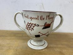 An early 19thc pearlware two handled footed cup, inscription God Speed The Plough, decorated with