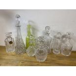 A collection of decanters, various ages and designs, a neon green/yellow bottle, tallest measures