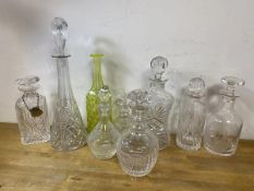 A collection of decanters, various ages and designs, a neon green/yellow bottle, tallest measures