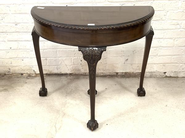 A George III style mahogany demi lune card table, the gadroon moulded fold over top revealing