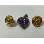 A white metal heart shaped locket with diamonds and amethysts to front and pierced to rear, measures