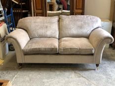 A contemporary two seat sofa, upholstered in grey crushed velvet, with squab cushions, raised on