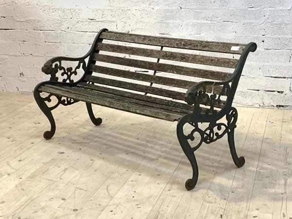 A cast iron garden bench, the scrolled ends with lion mask terminals, and slatted seat, (Slats A/