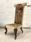 A Victorian rosewood prie dieu, the needlework upholstery worked with birds amongst foliate,
