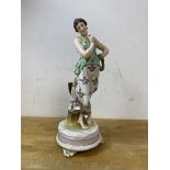 A continental figure of lady with reef on arm, on footed base, measures 27cm high