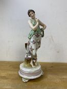 A continental figure of lady with reef on arm, on footed base, measures 27cm high