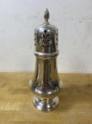 A 1963 Birmingham silver sugar castor with makers mark HCD, with flame finial, measures 18cm high,