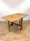 A Vintage mid century teak drop leaf dining table, the top supported by two swing legs and panel end