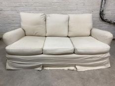 A two seat sofa, circa 1930s/1940s, with later fitted natural cotton cover and feather filled