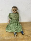 A Victorian doll, the head with wax exterior, ceramic arms and legs with painted boots, on stuffed