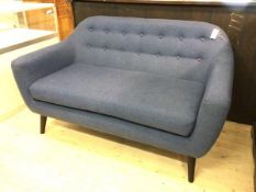 A contemporary two-seater sofa upholstered in buttoned deep blue fabric with a squab cushion