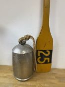 A silver painted cow bell and a decorative oar numbered 25, measures 127cm (2)