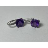 A pair of amethyst and diamond earrings, the cushion cut amethysts in mounts marked 14k