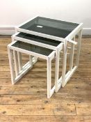 A nest of three tables, smoked plate glass tops on white painted frame, H48cm, W48cm, D38cm