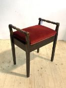 An early 20th century stained walnut piano stool, the turned handles over velvet upholstered