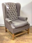 A Georgian style wingback armchair, the grey linen button back upholstery enriched with studded