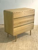 A mid century modern light oak chest, fitted with three drawers, raised on turned supports, H90cm,