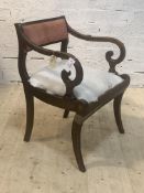 A Regency mahogany elbow chair, the upholstered back rest and seat enclosed by scrolled open arms,