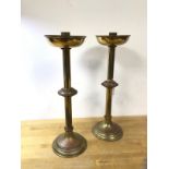 A pair of Arts and Crafts candlesticks with bowl drip tray, saucer knop to centre on circular